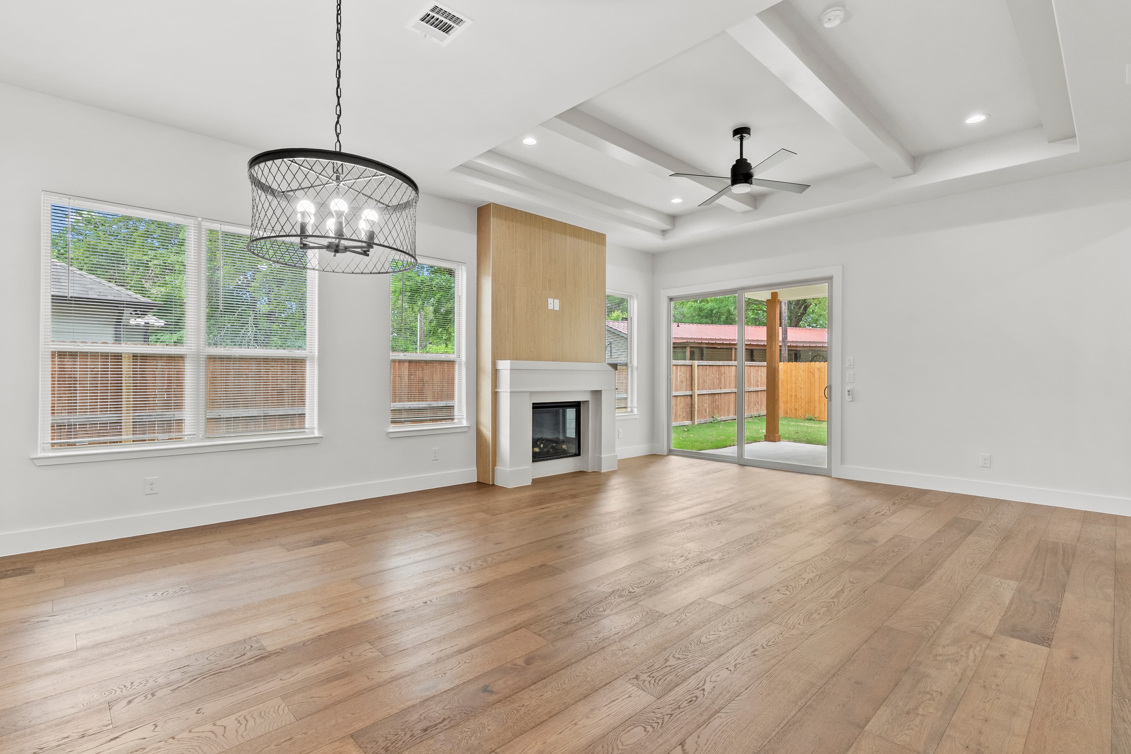 A completed ROSÖ Homes custom living and dining space with a coffered ceiling and fireplace
